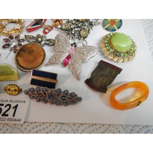 521 - In excess of thirty assorted brooches, badges etc.,