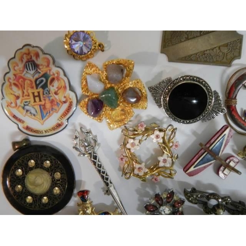 521 - In excess of thirty assorted brooches, badges etc.,