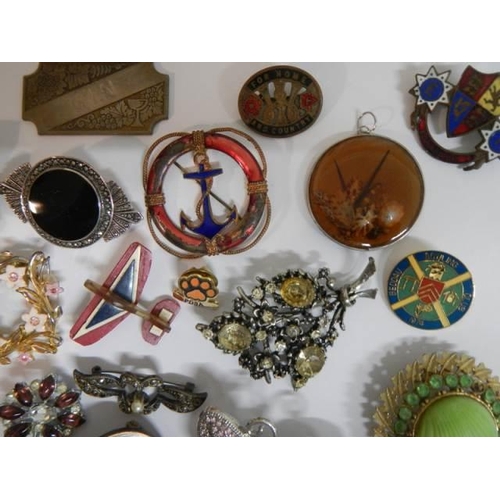 521 - In excess of thirty assorted brooches, badges etc.,