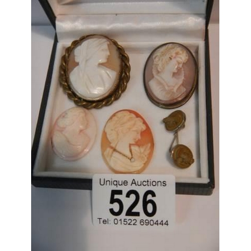 526 - Two cameo brooches, two un-mounted cameos and one other item.