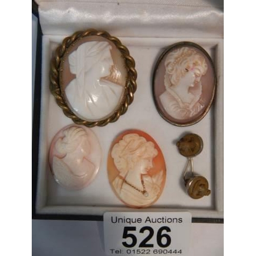 526 - Two cameo brooches, two un-mounted cameos and one other item.