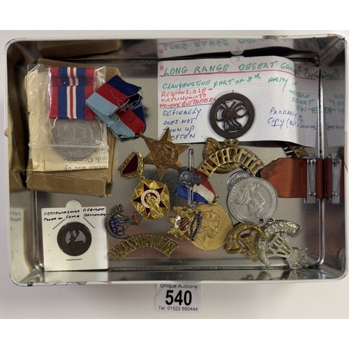 540 - A quantity of military cap badges, medals etc