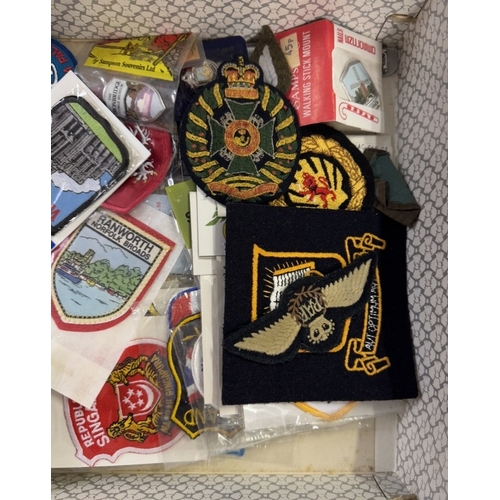 554 - A quantity of cloth military badges & a quantity of tourist patches etc