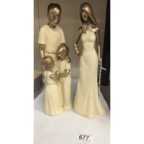 677 - A pair of stylized resin figures.