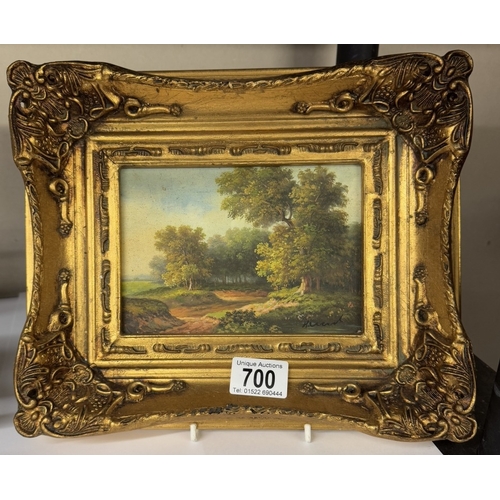 700 - A gilt framed over painted print of a woodland scene