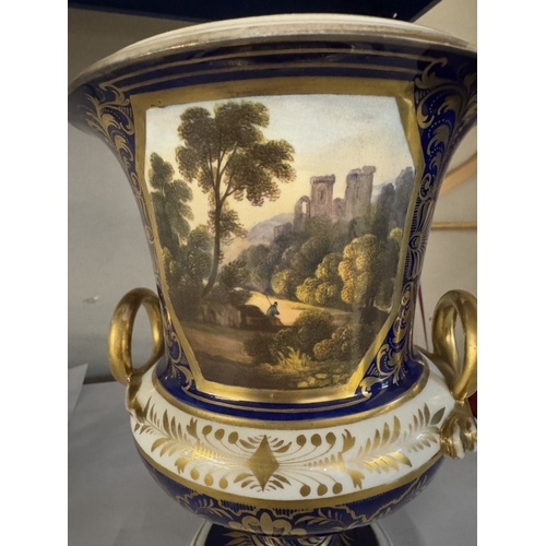 775 - A Derby cobalt ground vase of campana form with gilt snake handles, painted with a traveller in a wo... 