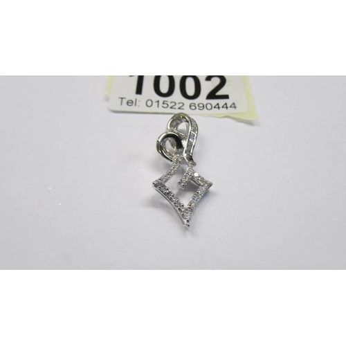 1002 - An ornate white gold and diamond pendant, 3.23 grams.