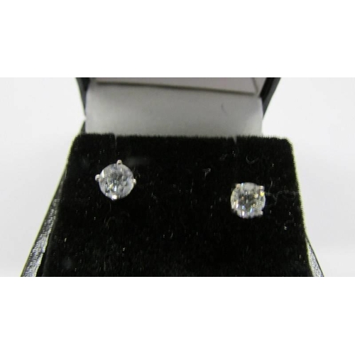 1004 - A pair of 80pt diamond studs set in white gold.