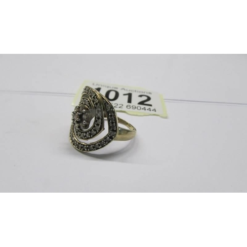 1012 - A large diamond swirl ring set in 9ct gold, size N, 3.37 grams.