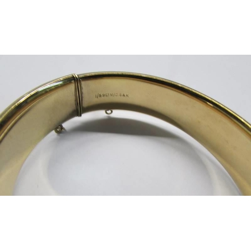 1018 - An engraved bangle marked 1/5 9ct M/C S & K.