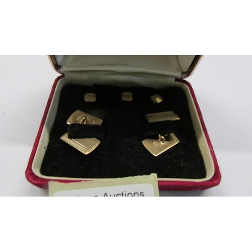 1020 - A pair of gold cuff links with three matching studs in original box.