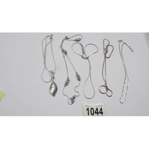 1044 - Three silver chains, a silver necklace and a silver leaf pendant.