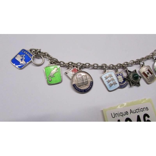 1046 - Twelve silver souvenir charms on a bracelet.