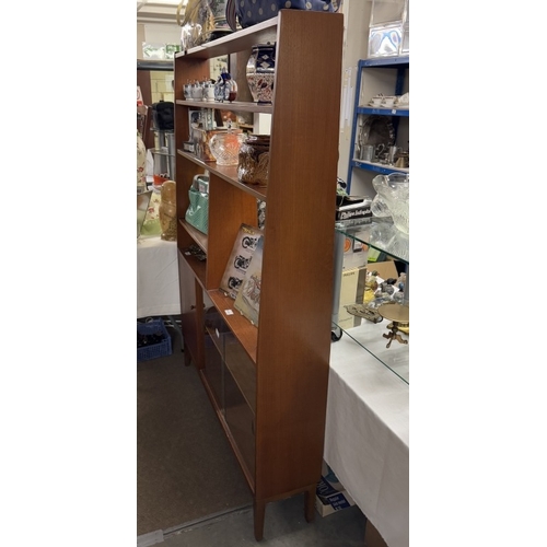 830E - A retro teak wall unit with cupboard and glazed bookcase