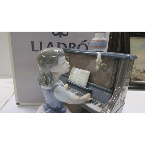 1057 - A boxed Lladro figure - Girl playing piano.