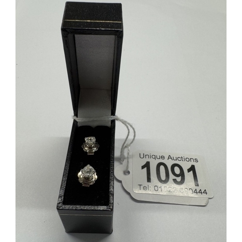 1091 - A pair of old mine cut diamond stud earrings, 0.6ct total in 18ct gold.