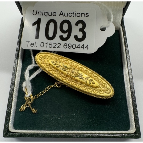 1093 - An antique brooch in 15ct hallmarked gold, finely chased gold work with safety chain, 4.5 grams.