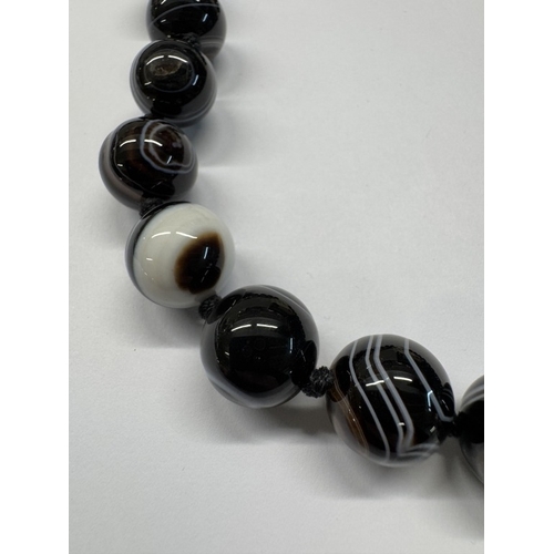 1098 - A banded agate necklace with silver clasp.