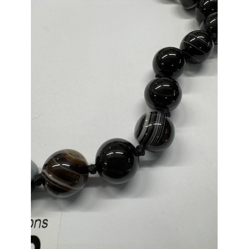 1098 - A banded agate necklace with silver clasp.