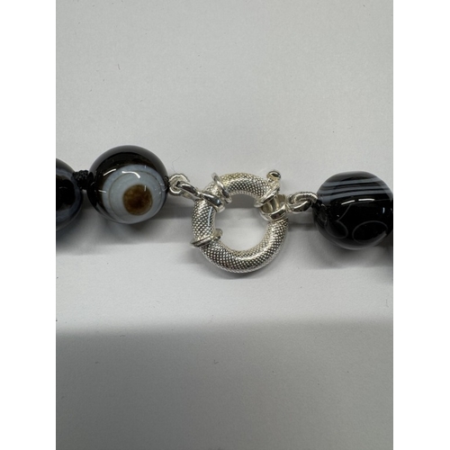 1098 - A banded agate necklace with silver clasp.