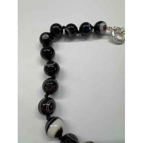 1098 - A banded agate necklace with silver clasp.