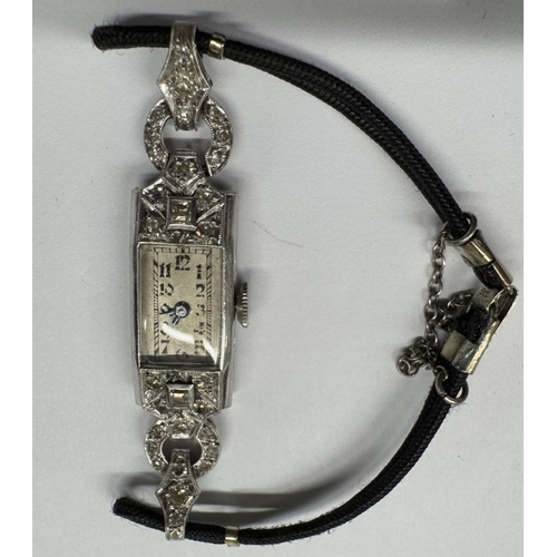 1103 - An art deco diamond watch set in platinum with cord strap, 9ct clasp to bracelet, 12.6 grams.