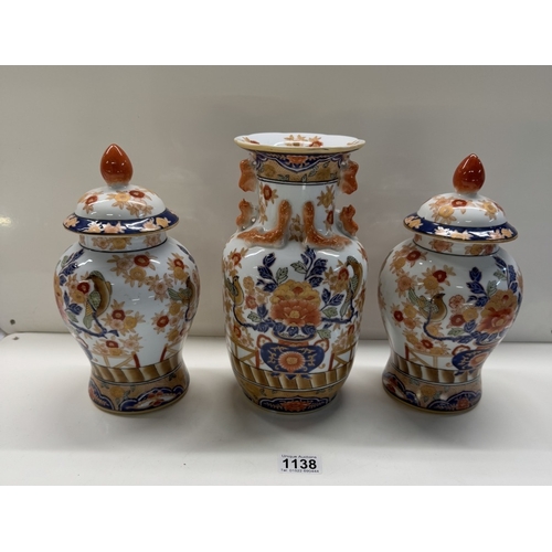 1138 - A Chinese pottery trio of 2 urns & centre vase