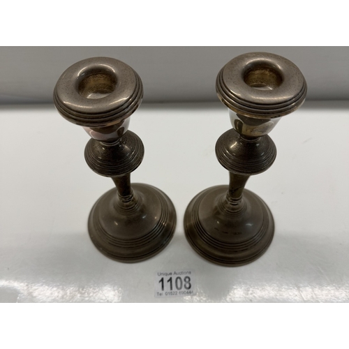 1108 - A pair of sterling silver filled candlesticks. Height 17.5cm