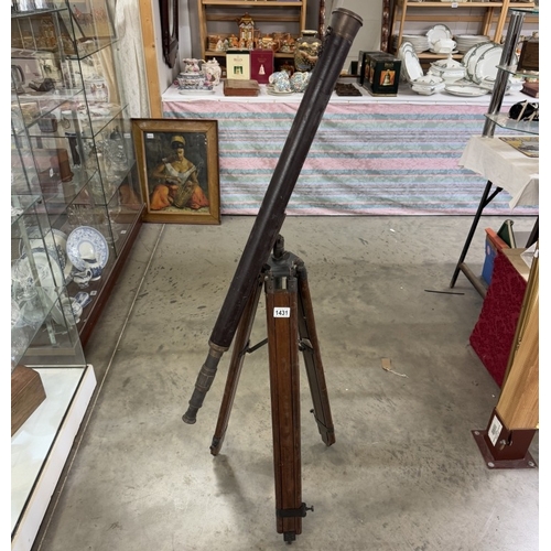 1431 - A patinated brass telescope on tripod base. Length 98cm.