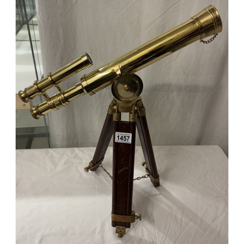 1457 - A polished brass telescope on tripod base. Length 43cm