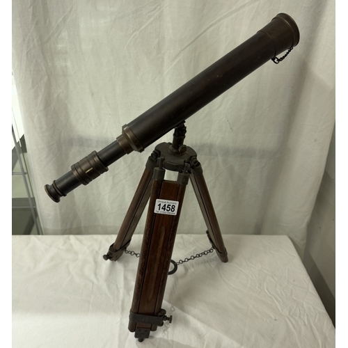 1458 - A patinated brass telescope on tripod base. Length 43cm