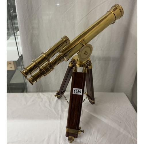 1459 - A polished brass telescope on tripod base. Length 43cm