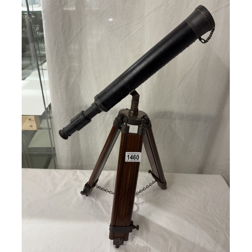 1460 - A patinated brass telescope on tripod base. Length 43cm