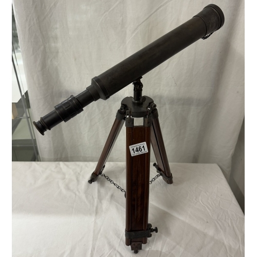 1461 - A patinated brass telescope on tripod base. Length 43cm