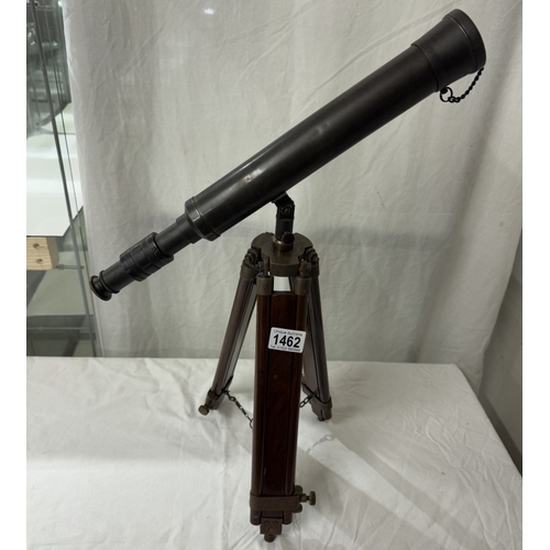 1462 - A patinated brass telescope on tripod base. Length 43cm