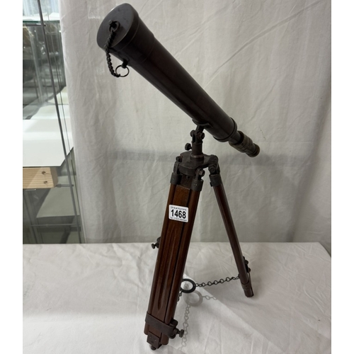 1468 - A patinated brass telescope on tripod base. Length 43cm