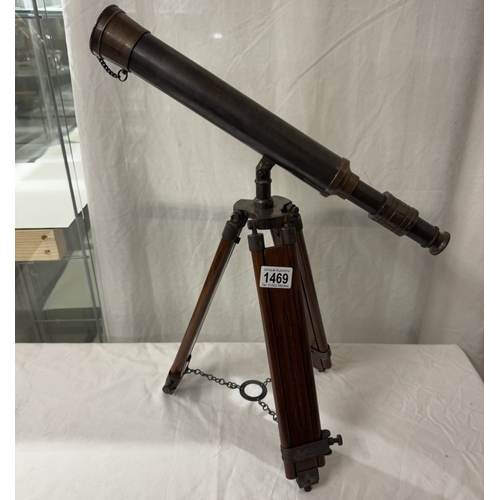 1469 - A patinated brass telescope on tripod base. Length 43cm