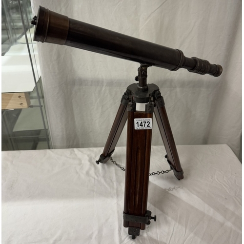 1472 - A patinated brass telescope on tripod base. Length 43cm