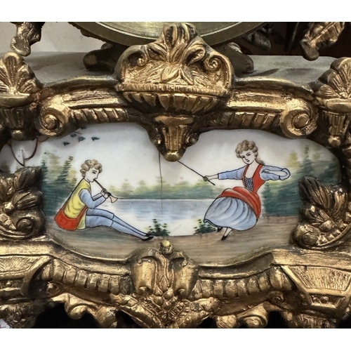 1545 - A 19th century gilt mantel clock surmounted figure with painted porcelain panels.