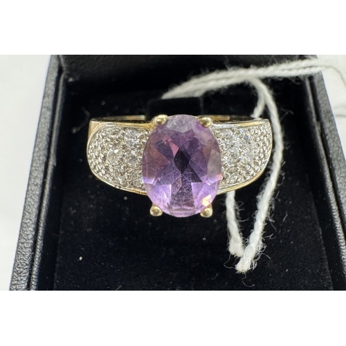 1100B - A gold ring set with amethyst tiny clear stones