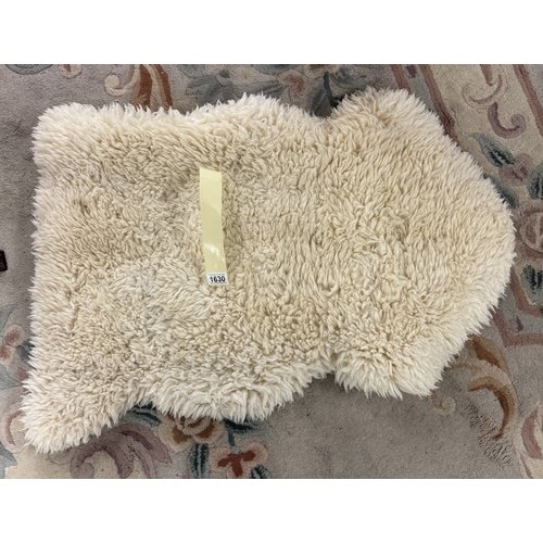 1630 - A short sheepskin rug (89 cm long)