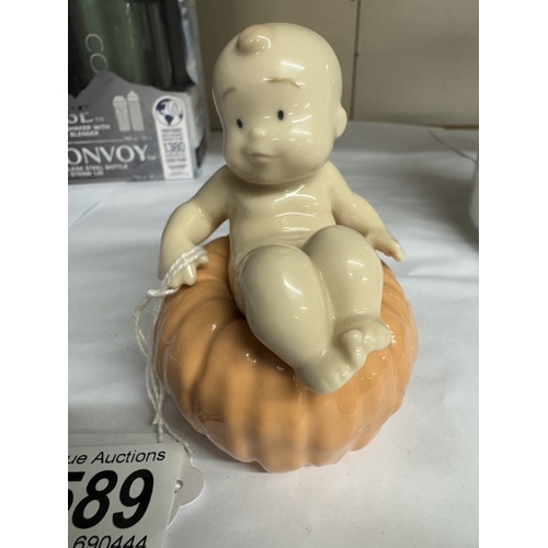 1589 - A NAO figure of a baby sat on a pumpkin.