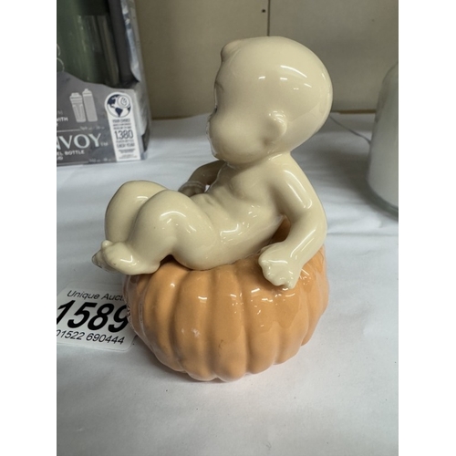 1589 - A NAO figure of a baby sat on a pumpkin.