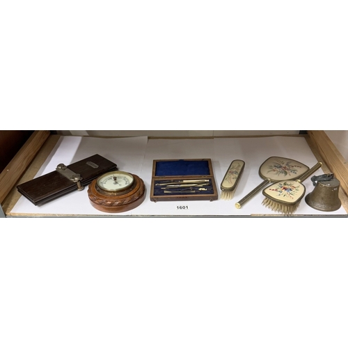 1601 - A shelf of miscellaneous collectables including barometer, geometry set & tie press etc.