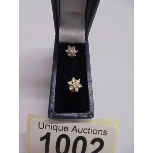 1002 - A pair of petal pattern gold diamond earrings.