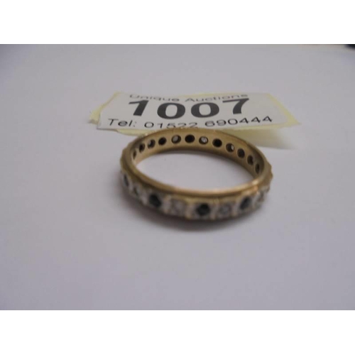 1007 - A 9ct yellow gold diamond and sapphire eternity ring, size O, 2.26 grams