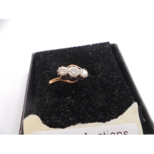 1009 - An 18ct yellow gold three stone diamond ring, size N, 3.02 grams.