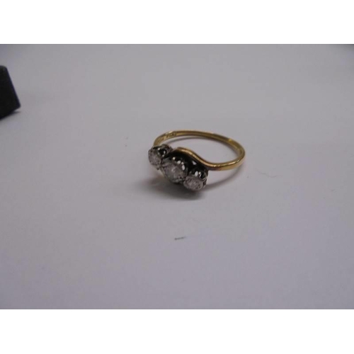 1009 - An 18ct yellow gold three stone diamond ring, size N, 3.02 grams.