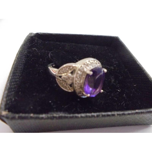 1012 - A white gold ring set large amethyst coloured stone surrounded by diamonds, size M half, 4.42 grams.