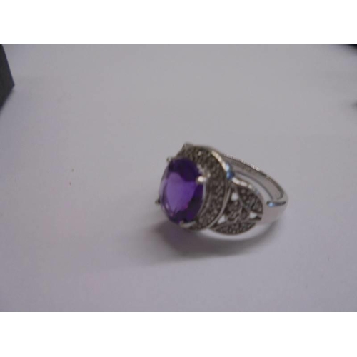 1012 - A white gold ring set large amethyst coloured stone surrounded by diamonds, size M half, 4.42 grams.